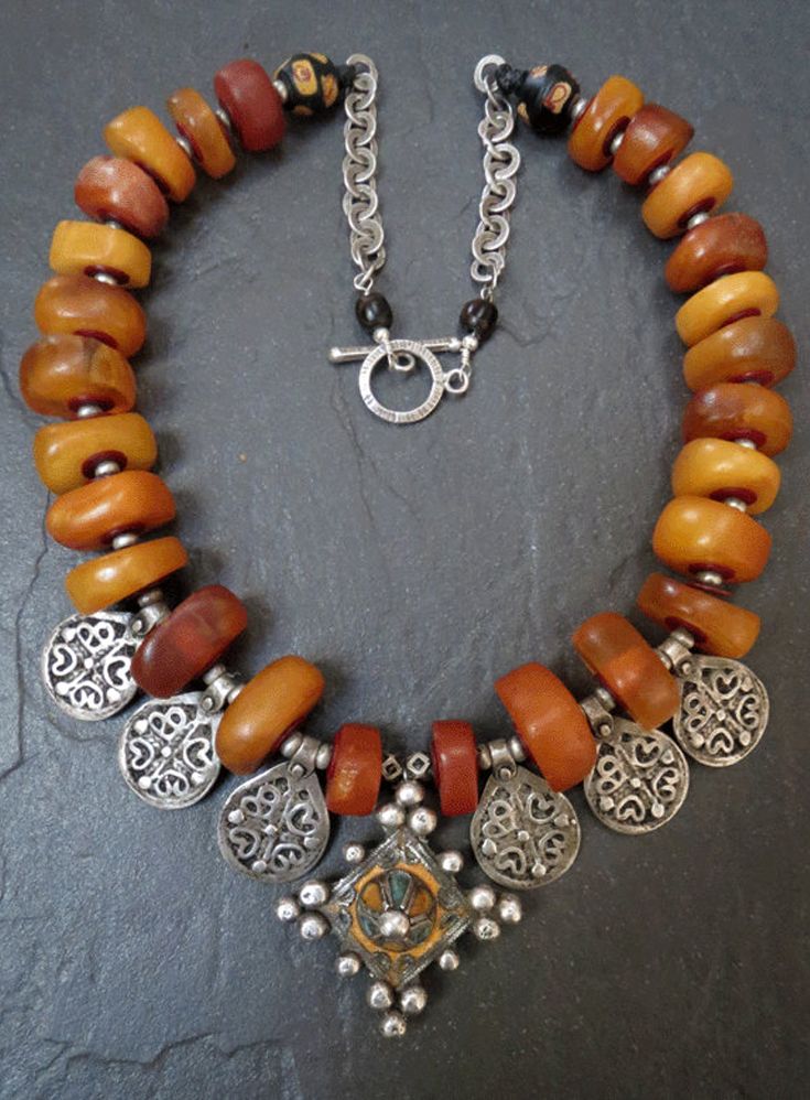 by Luda Hunter | Genuine antique Moroccan natural amber beads are combined with an enamelled Berber cross pendant from Tiznit (Morocco) and six Berber silver charms.  The last two beads are antique Venetian King Bicone beads dating from the late 1850s - 1920s  | Sold Collar Hippie, Moroccan Jewelry, Turkish Jewelry, Chunky Jewelry, Natural Amber, Amber Beads, African Jewelry, Amber Jewelry, Diy Schmuck