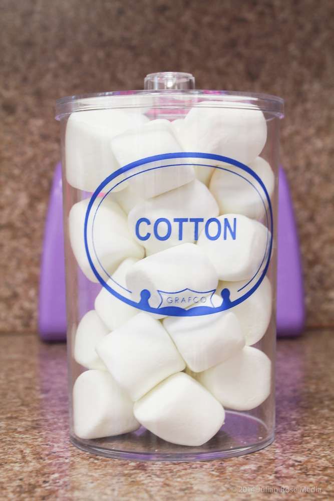 a jar filled with white marshmallows sitting on top of a counter