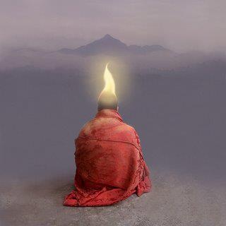 a person sitting on the ground with a lit candle in their head