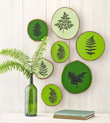 a table topped with green plates and a vase filled with plants on top of it