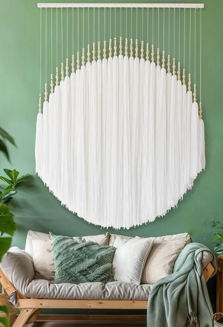 a living room with green walls and white drapes hanging from the ceiling over a couch