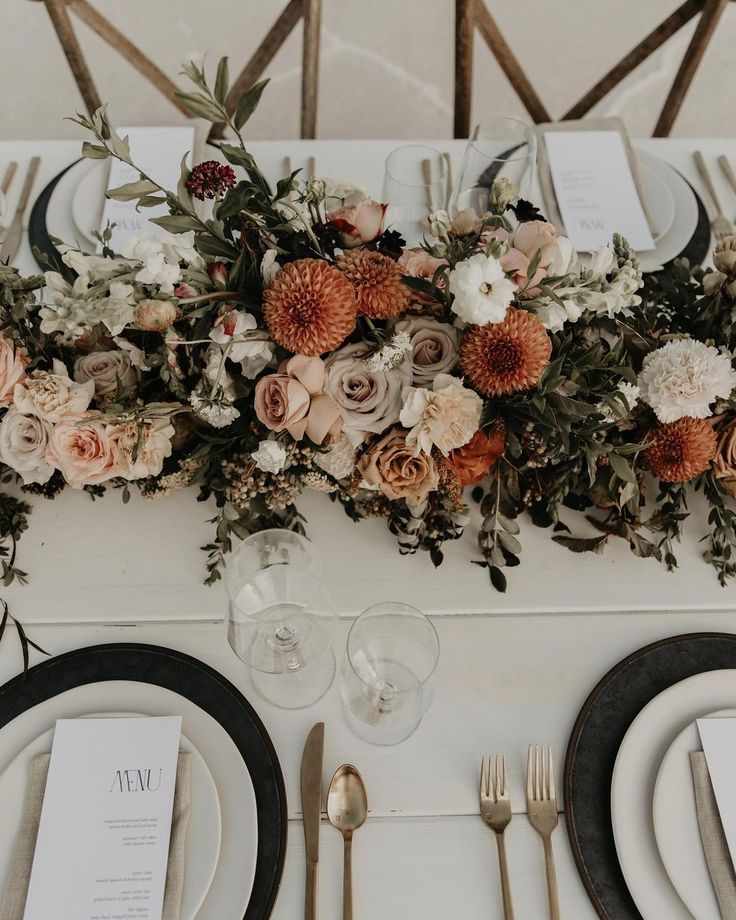 the table is set with flowers and silverware