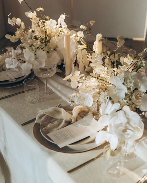 the table is set with white flowers and candles