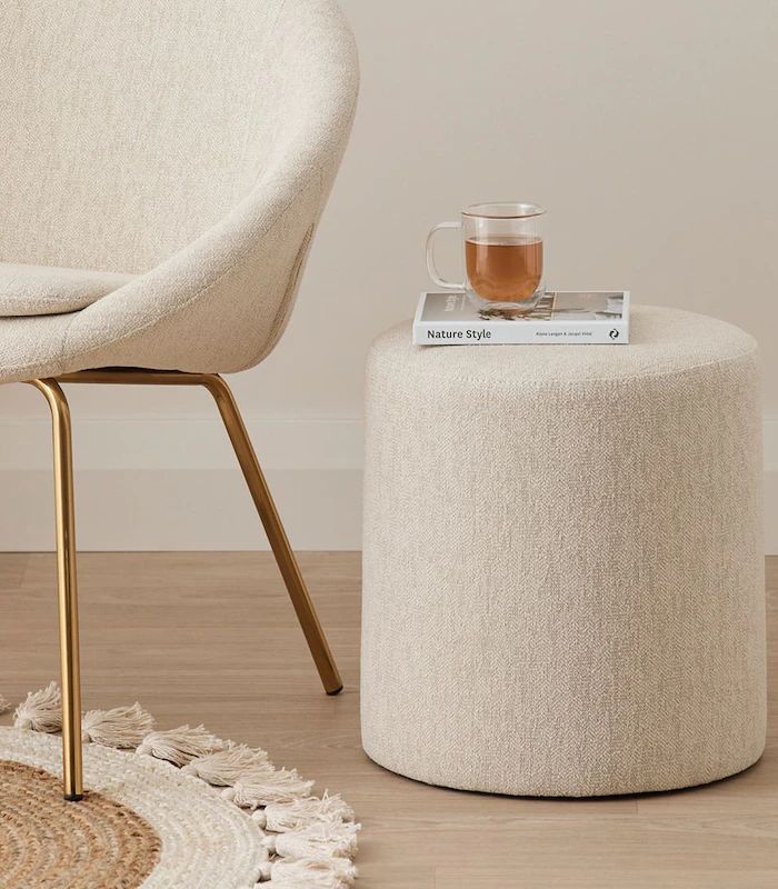 a white chair sitting next to a round ottoman