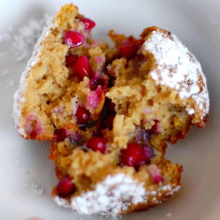 two cranberry and pomegranate muffins on a white plate