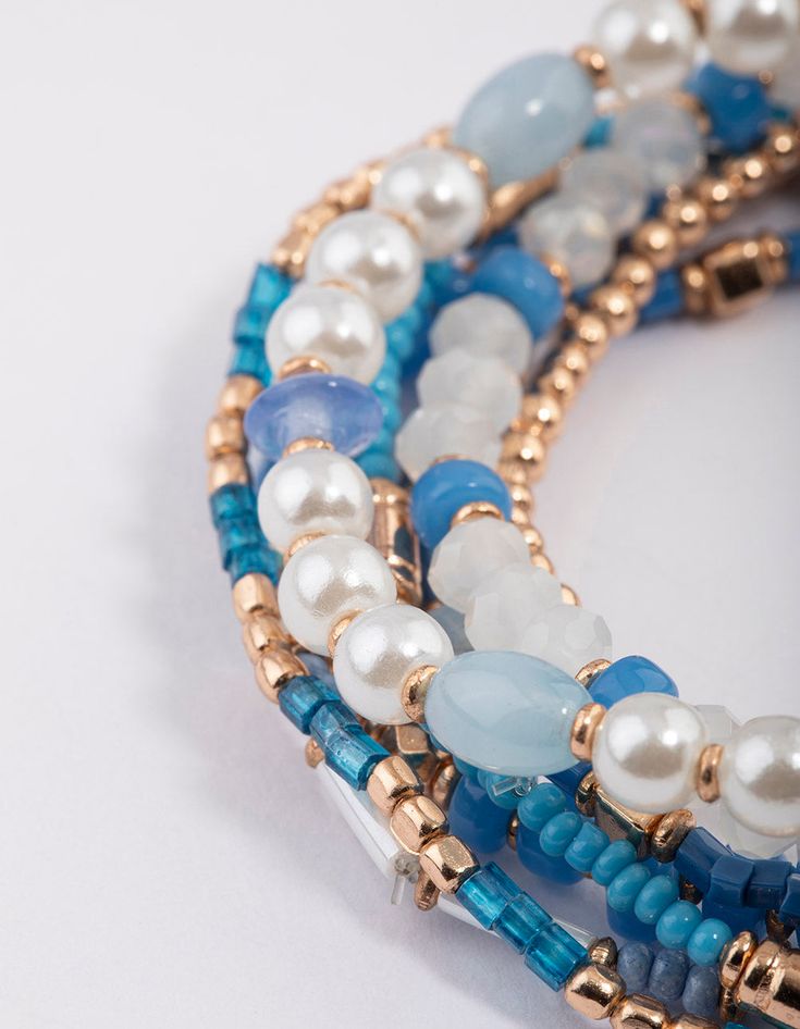 Accessorise for the seaside with our collection of on-trend pieces from the Hamptons Collection! Designed with resort-wear and beach-wear trends in mind, our Hamptons collection features rustic, bohemian influences - from unique textures, raffia and fringe, to delicate beading. | Lovisa Gold Mixed Facet Pearly Bead Pack Bracelet Blue Bohemian Strand Bracelets, Blue Bohemian Strand Bracelet, Bohemian Stretch Bracelet For Vacation, Bohemian Beaded Stretch Bracelet For Summer, Bohemian Hand-strung Beaded Bracelets For Summer, Hand-strung Bohemian Beaded Bracelets For Summer, Bohemian Summer Beaded Bracelets Hand-strung, Turquoise Bohemian Wrap Bracelet For Beach, Bohemian Hand-strung Stretch Bracelet For Vacation