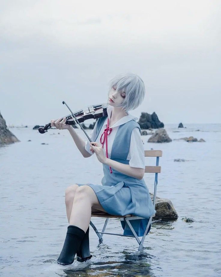 a woman sitting on top of a chair playing a violin in the middle of water