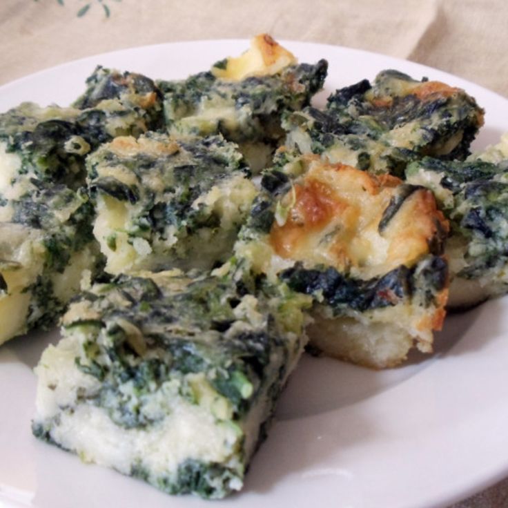 spinach and cheese casserole on a white plate with a brown table cloth