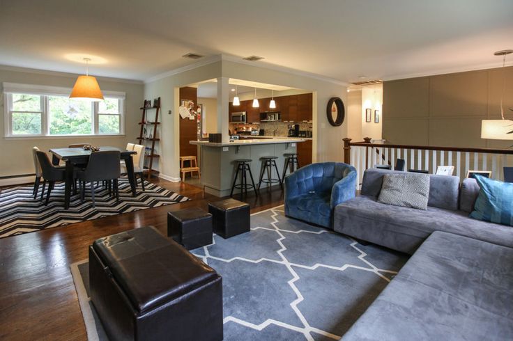 a living room filled with furniture next to a kitchen and dining area in a home