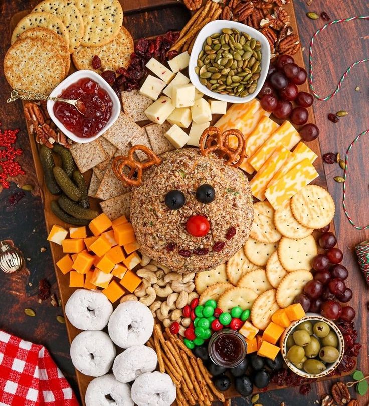 a wooden platter filled with cheese, crackers and other snacks