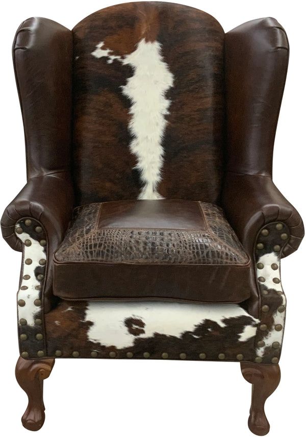 a brown and white cowhide chair with an animal print pattern on the armrests