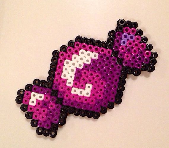 a close up of a piece of art made out of plastic beads with an object in the shape of a pacman