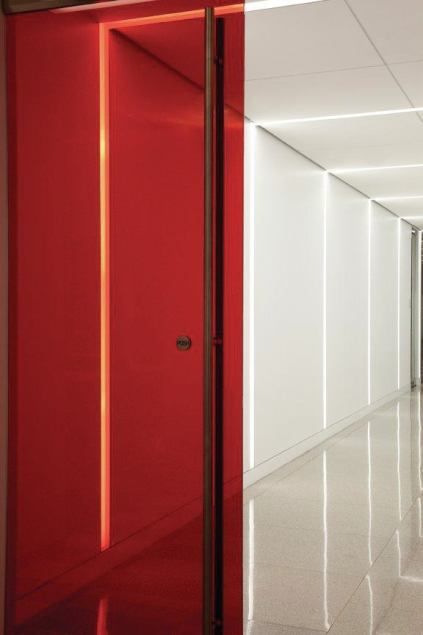 an empty hallway with bright red doors and white walls is seen in this image from the inside