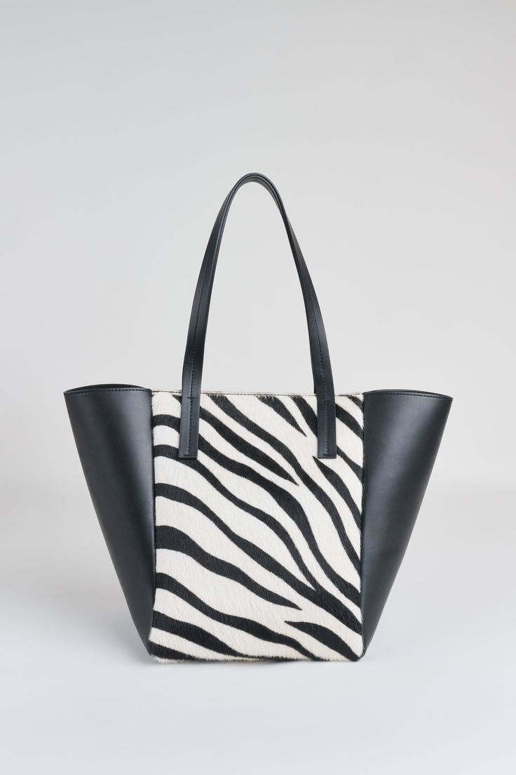 Fashion meets function in our exclusive Elie Tahari tote. Handcrafted in Italy, this tote has a striking design of zebra printed calf hair mixed with luxe Napa Leather. The spacious Suede interior features a slip pocket & a zipper closure to protect all your essentials. Elie Tahari Exclusive Zebra Calf Hair Napa Leather Tote 100% Leather Made in Italy Approx. Measurements: Base 7" W x 6"D, 13 "H, Top Opening 17 " W, Strap 20 " L W9R57103 Rectangular Calf Hair Bag For Shopping, Calf Hair Rectangular Shopping Bag, Black Calf Hair Rectangular Bag, Black Calf Hair Bag With Leather Handles, Chic Zebra Print Shoulder Bag For Everyday Use, Chic Black Bag With Zebra Print, Chic Black Bags With Zebra Print, Everyday Use Zebra Print Tote Bag, Everyday White Zebra Print Bag