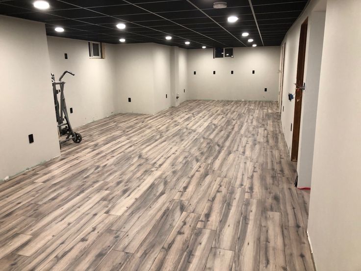 an empty room with hard wood flooring and white walls in the background is a gym