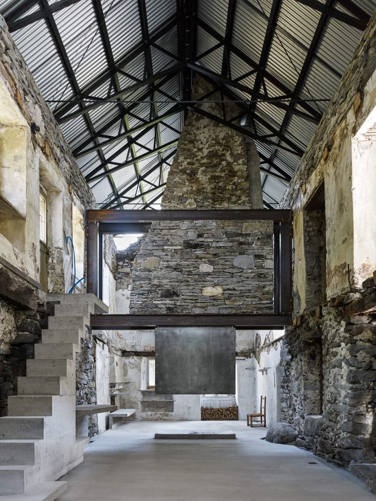 an old building with stone walls and stairs leading up to the second floor that has been converted into a living area