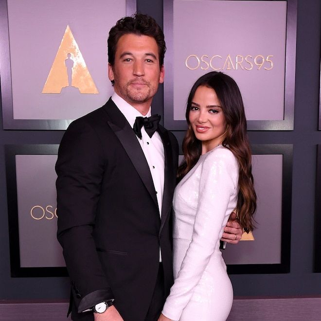 a man and woman standing next to each other on a red carpet