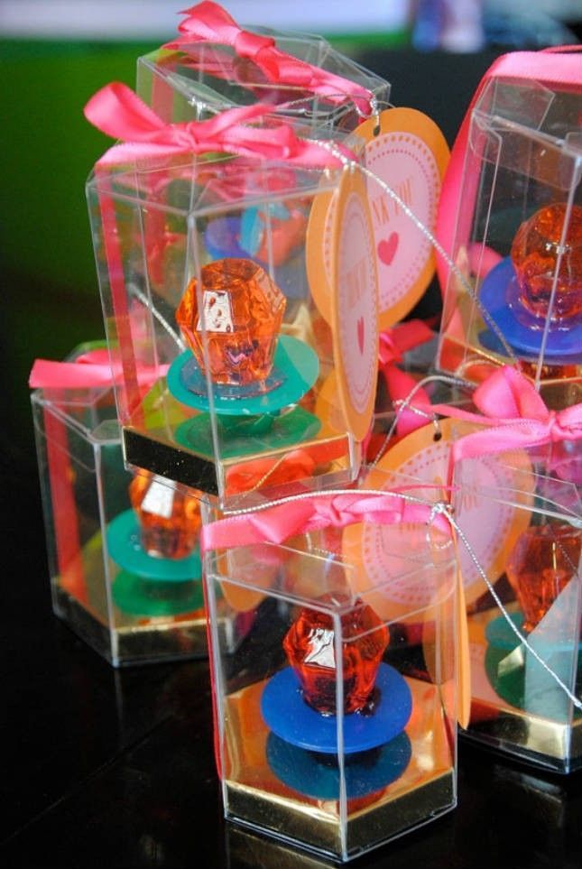 four clear boxes filled with different types of candies on top of a black table