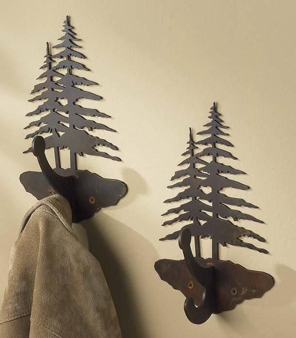 two metal deer and bear head hooks on a wall next to a coat rack with trees