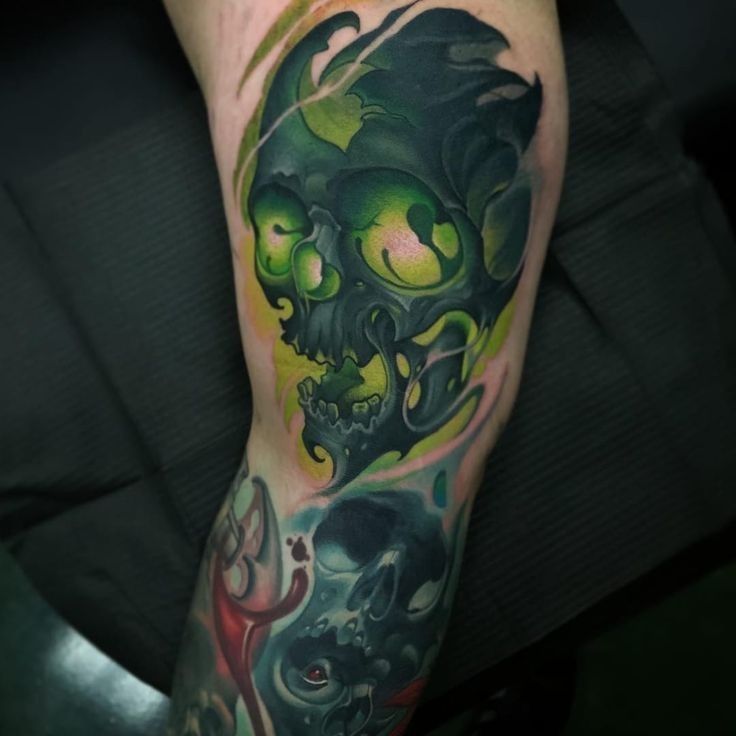 a man's leg with tattoos on it and an image of a skull in the middle