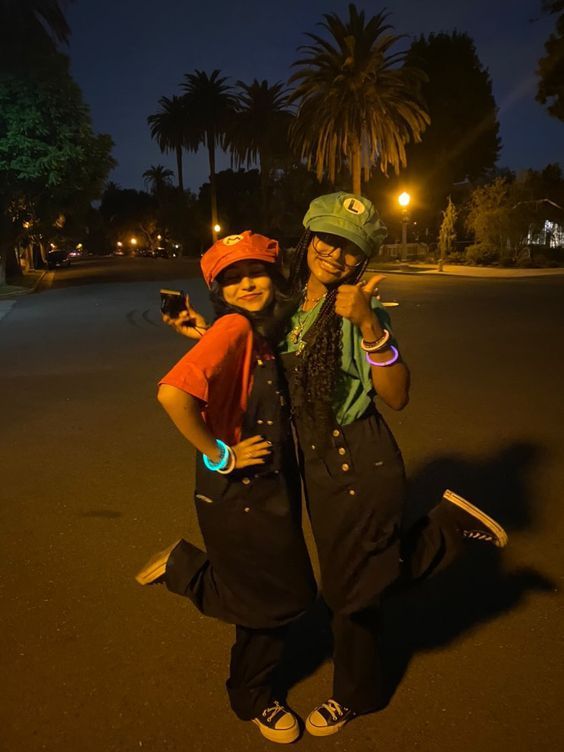 two people standing in the middle of a street at night with their arms around each other