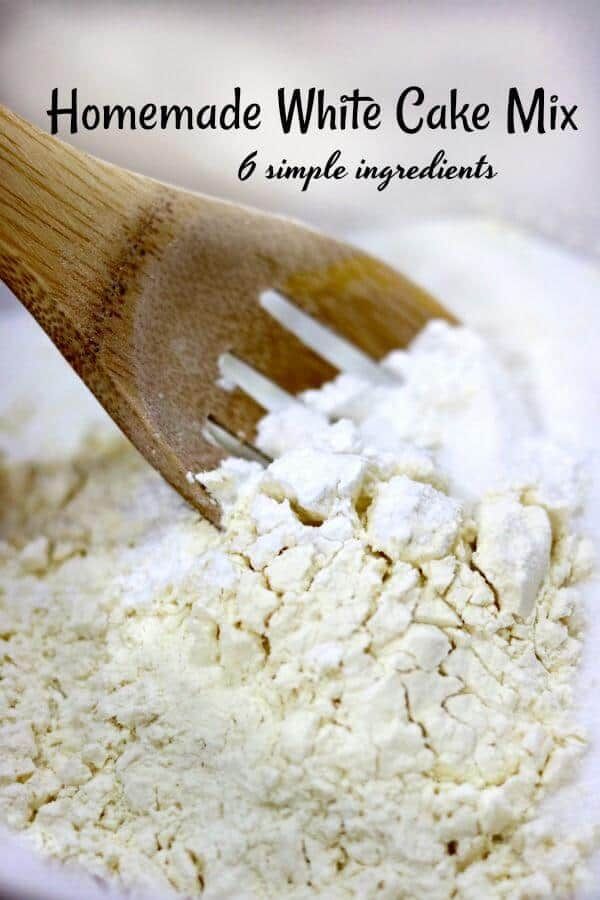 homemade white cake mix in a bowl with a wooden spatula on the side and text overlay that reads homemade white cake mix 6 simple ingredients