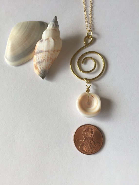 Genuine Hawaiian Puka Shell gold plated spiral wire necklace set on an 18 inch gold plated chain finished with a gold plated lobster clasp. The gold plated chain is nickel free. This beautiful and rare Hawaiian Puka shell was hand picked from the beaches of Hawaii. It makes a great Gold Round Pendant Necklace For Beach, Spiral Brass Necklace For Gift, Gold Spiral Necklaces For Jewelry Making, Adjustable Gold Spiral Necklace, Adjustable Spiral Gold Necklace, Adjustable Spiral Jewelry For Beach, Gold Spiral Jewelry For The Beach, Spiral Wire Wrapped Jewelry For Beach, Gold Spiral Necklace Nickel Free