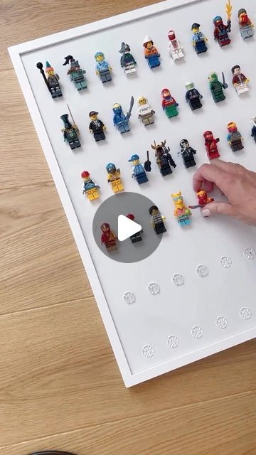 someone is playing with lego minifigure figures on the white board, which has been placed in front of them