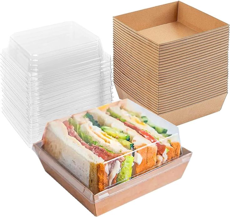 several different types of sandwiches stacked on top of each other in cardboard boxes with lids