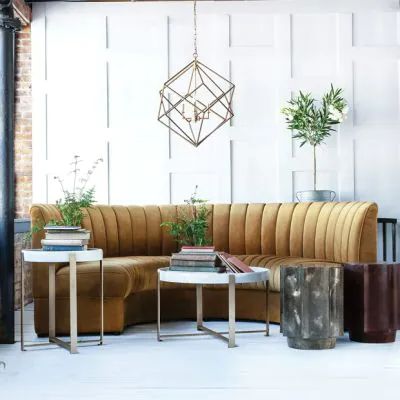 a living room filled with lots of furniture next to a wall mounted planter and potted plants