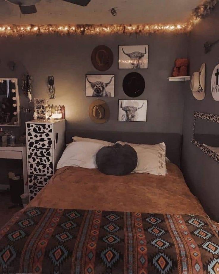 a bed room with a neatly made bed and many pictures on the wall above it