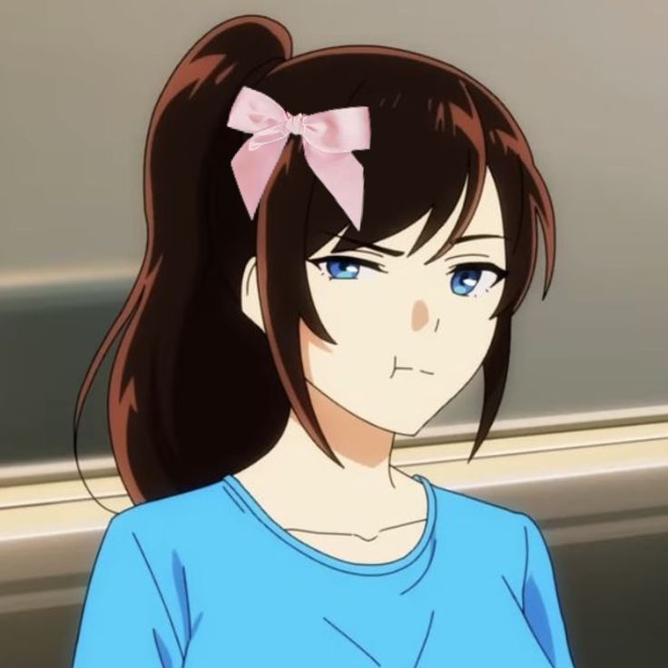 a girl with long brown hair wearing a blue shirt and a pink bow in her hair