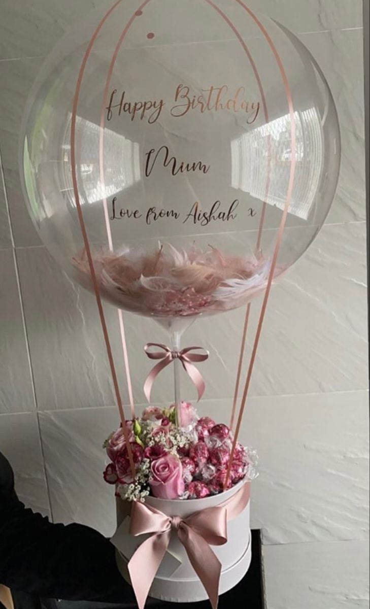 a clear balloon with pink flowers in it