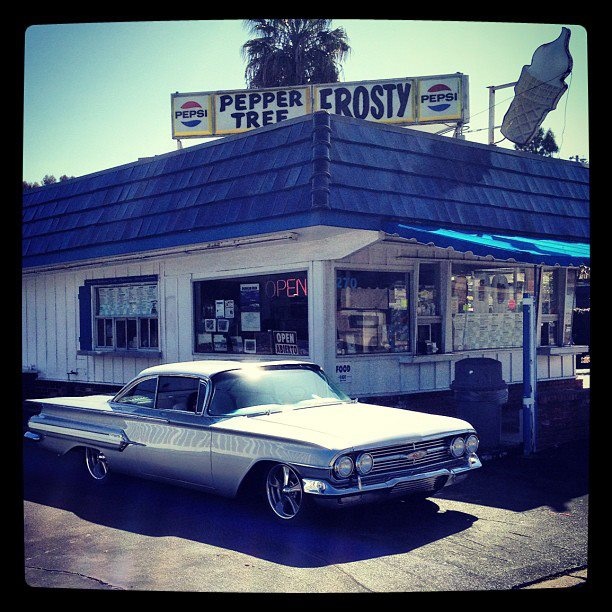 an old car parked in front of a store