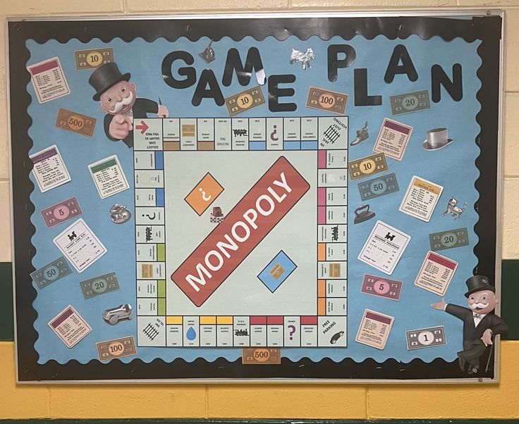 a monopoly board game is displayed on the wall in front of a school bulletin board