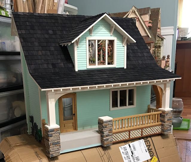 a doll house sitting on top of a cardboard box