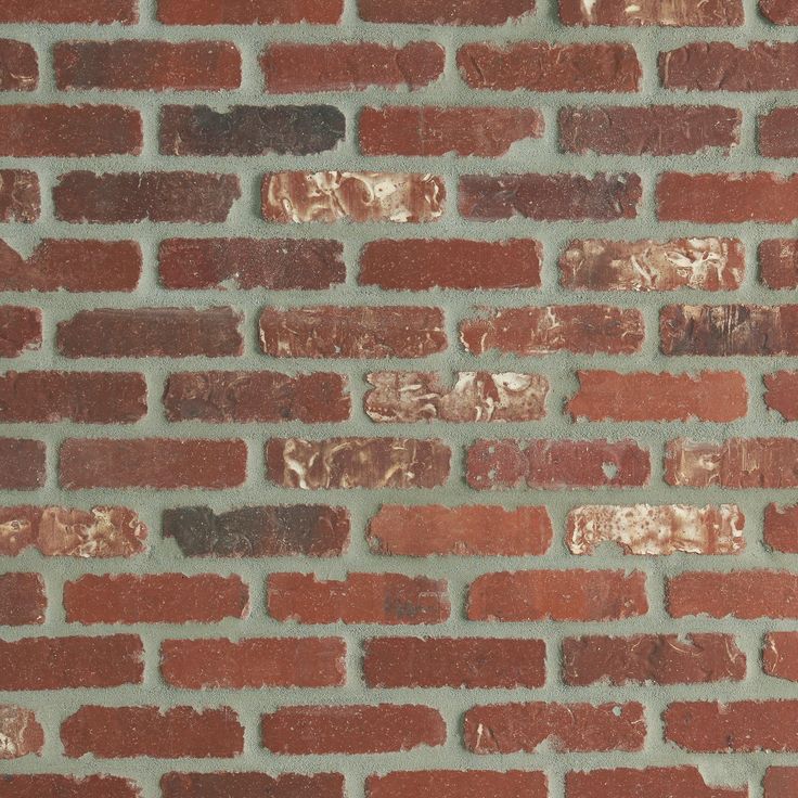 an old brick wall with red and brown bricks