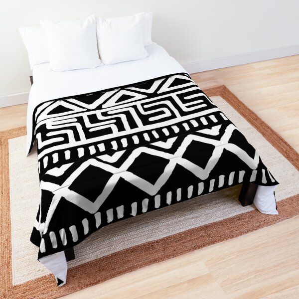 a black and white bed spread on top of a wooden floor