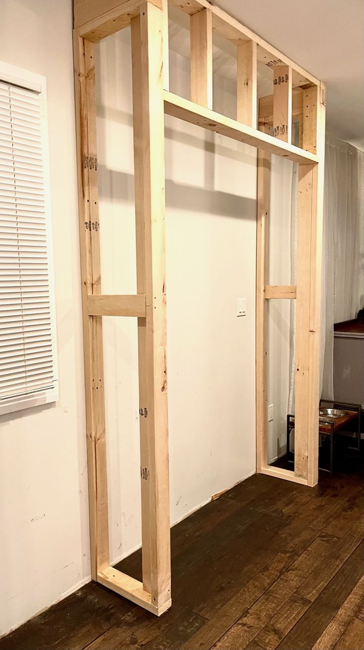 an unfinished room with wood floors and white walls