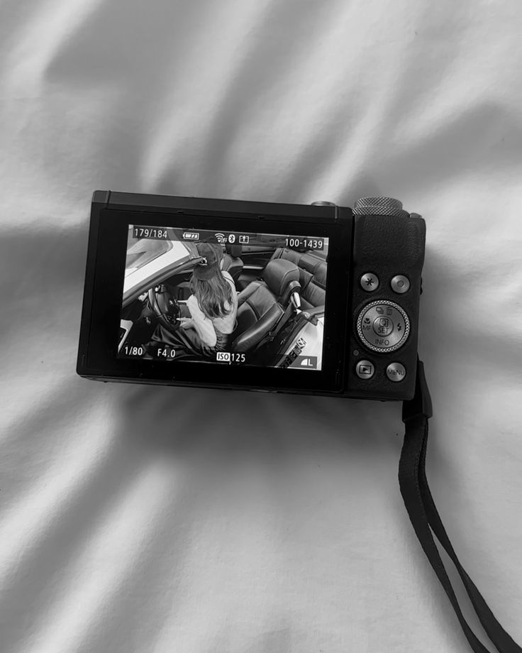 a black and white photo of a camera on a bed