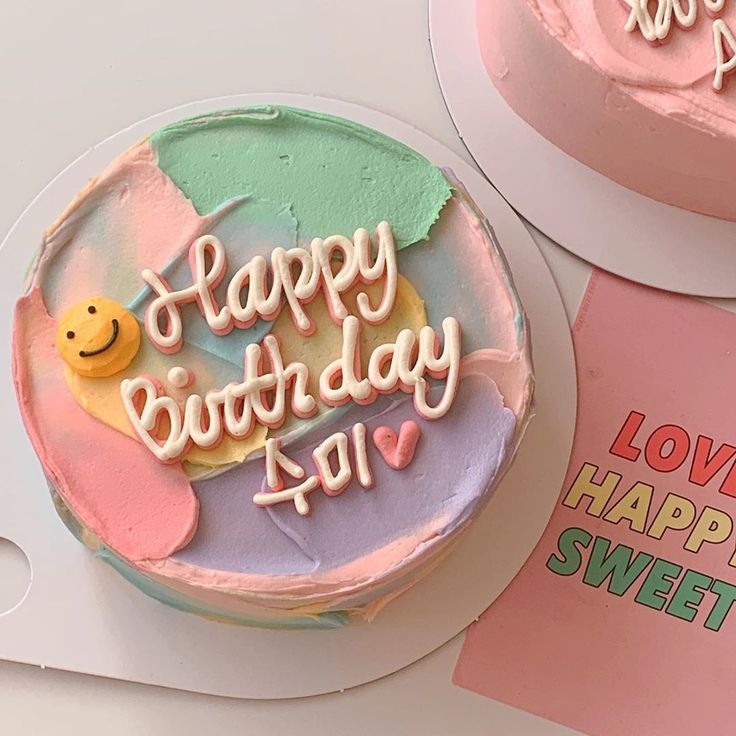 two birthday cakes sitting on top of a table next to each other with happy birthday written on them