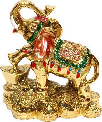 an elephant figurine sitting on top of gold coins