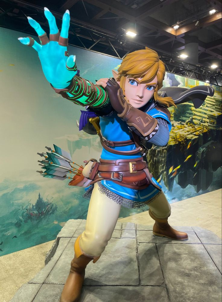 the legend of zelda statue is displayed in front of a wall with a painting on it