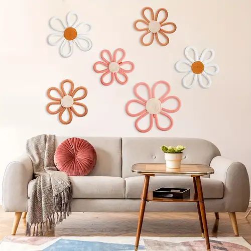 a living room with flowers on the wall and a table in front of it next to a couch