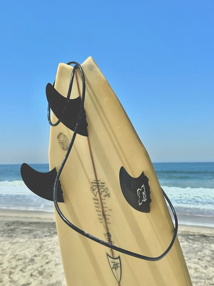 a surfboard is propped up on the beach