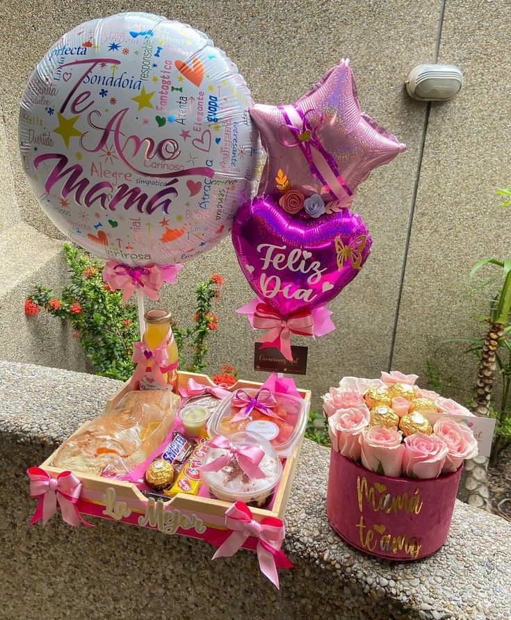 some balloons and other items are on a table with flowers in the vases next to it