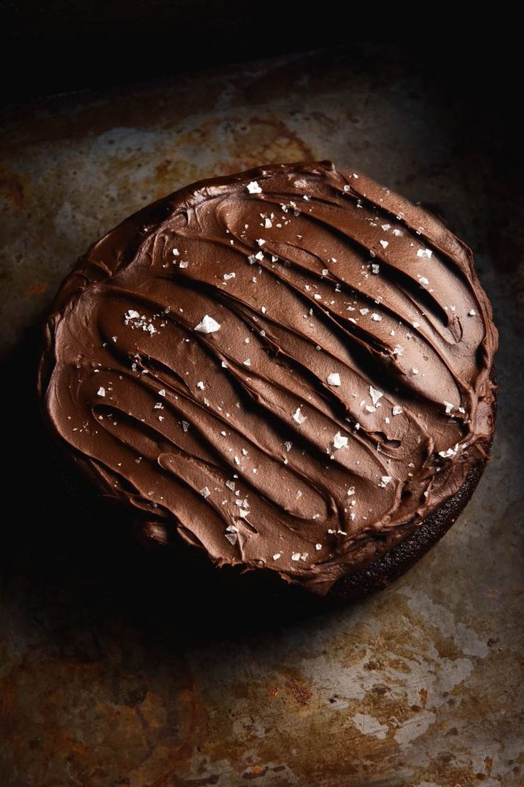 a piece of chocolate cake with frosting on it sitting on top of a table