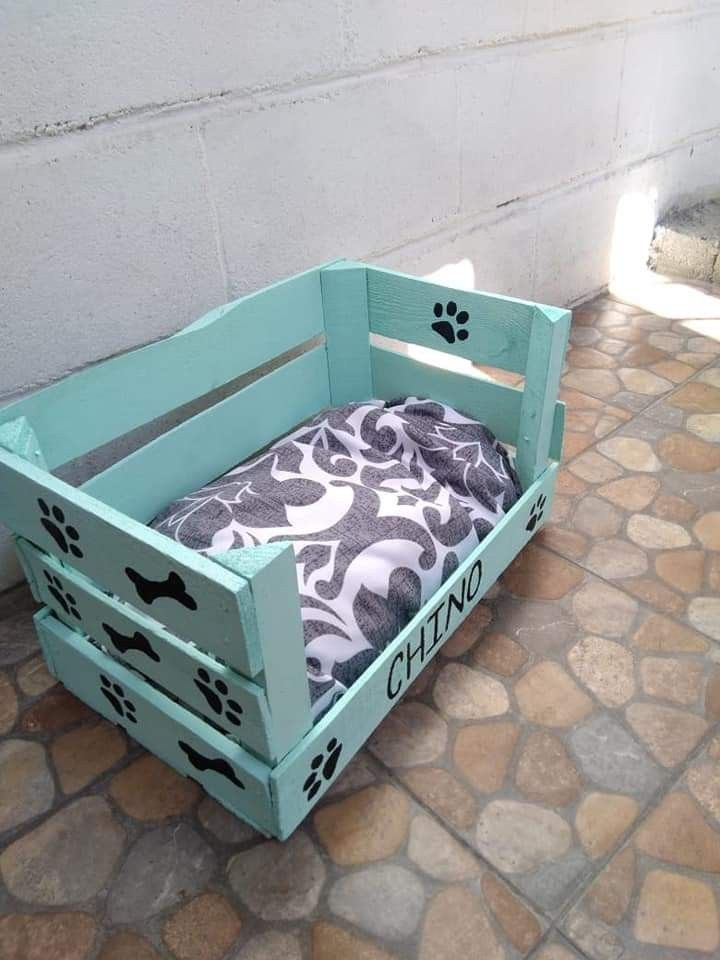 a dog bed made out of wooden crates with paw prints on the outside and inside