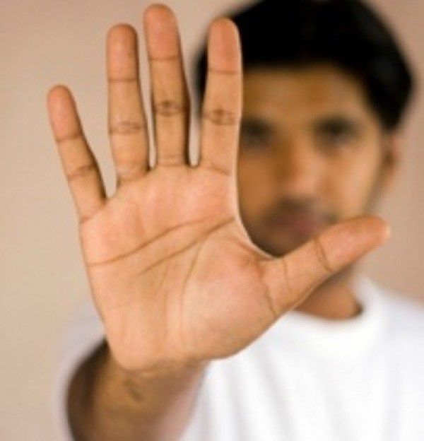 a man is holding his hand up in the air with one hand and two fingers out