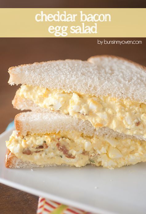 a close up of a sandwich on a plate with the words cheddar bacon egg salad